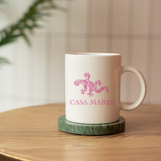 White mug with the gecko and wordmark in pink